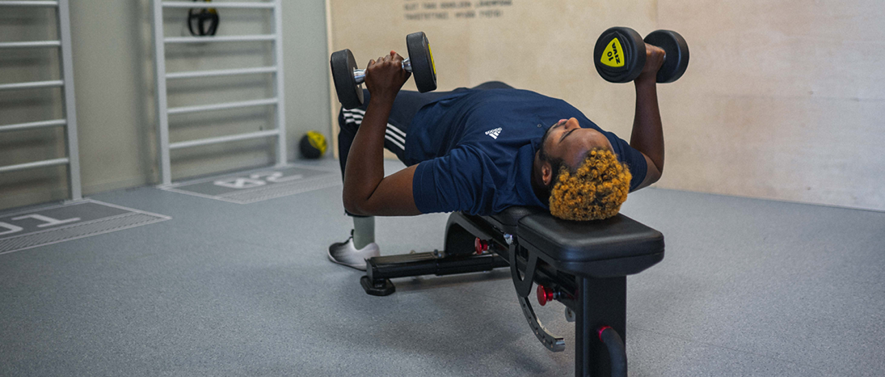 Man träna på bänk med vikter