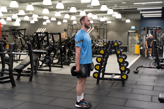 Man på Gym gör Utfallssteg Bakåt