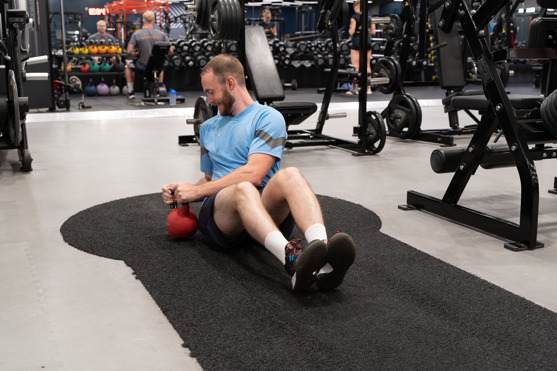 Man på gym utför russian twist