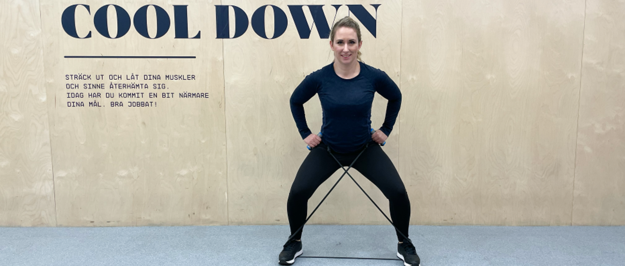 Kvinna styrketränar med gummiband på gymmet