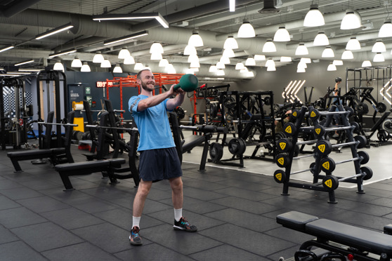 Man på gym gör kettlebell swing
