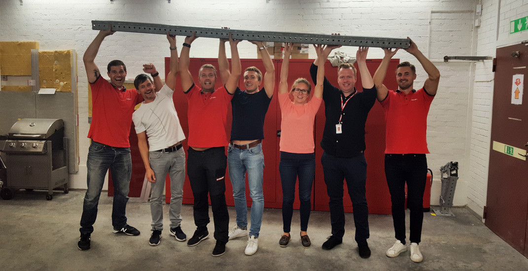 The Hilti team all together carries a big piece of steel