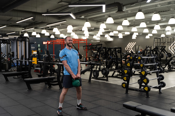 Man på gym gör Kettlebell Swings