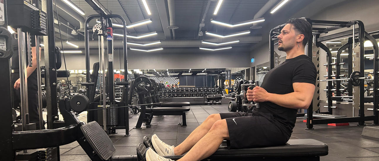 Man kör sittande kabelrodd på gymmet