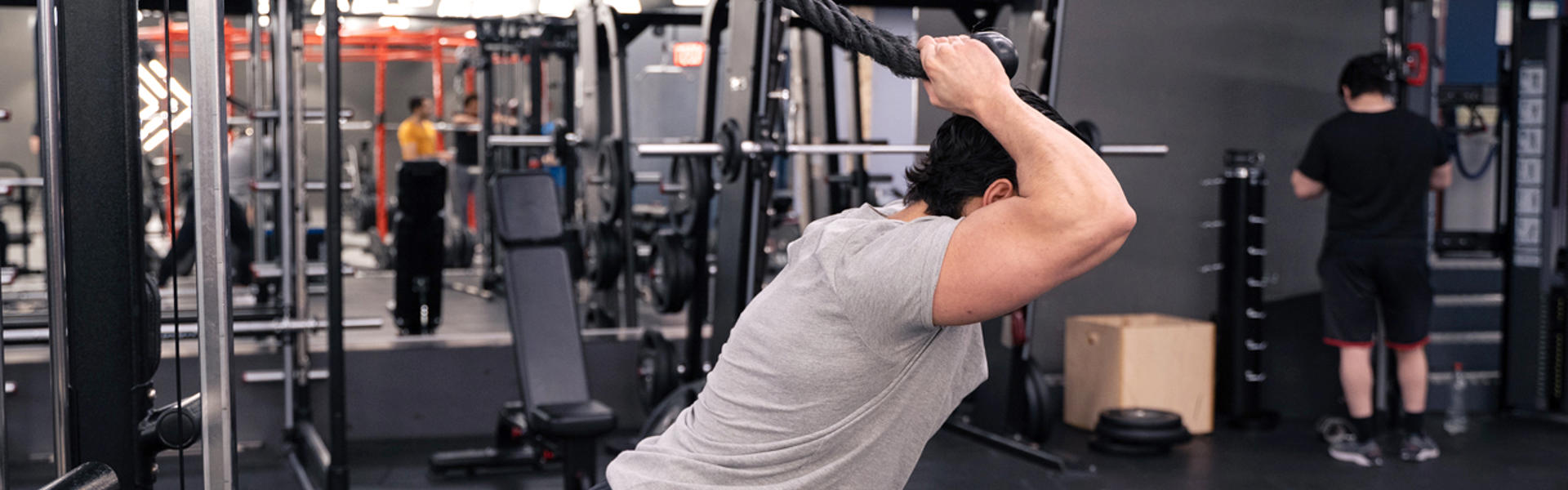 Man gör overhead-triceps extension med maskin
