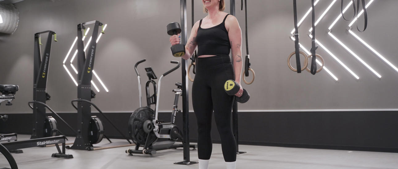 Kvinna kör biceps curl på gymmet