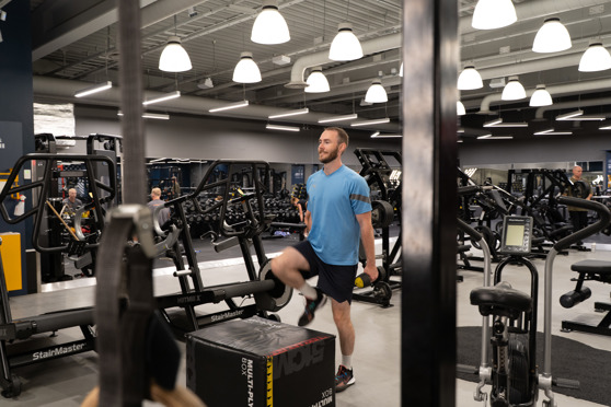 Man på gym gör Step Ups på Box