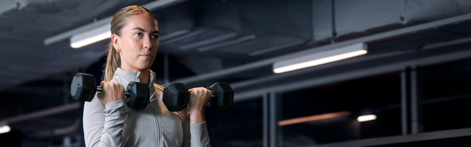 Fokuserad medlem som tränar armar på gymmet