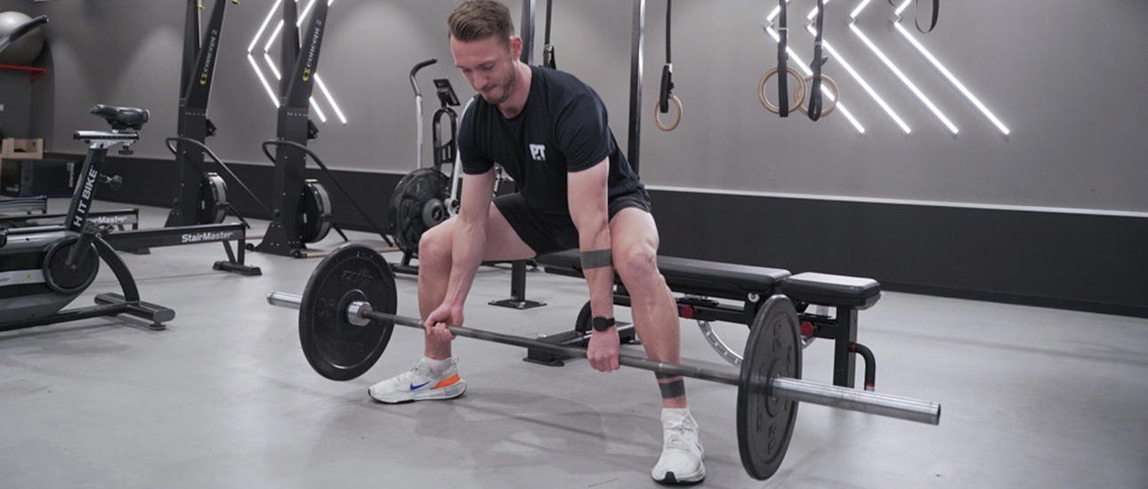 Man gör sumo squat med vikter på gymmet